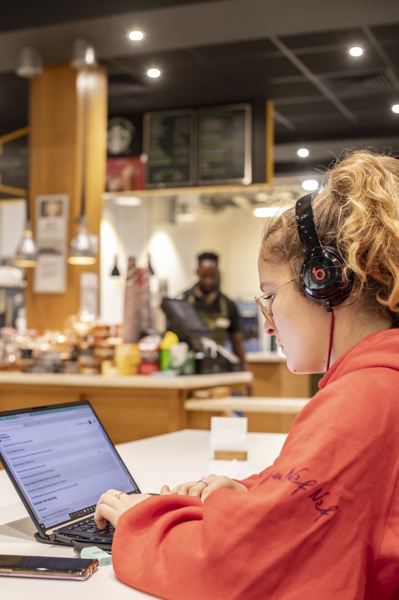 Student listening to music and working on a laptop