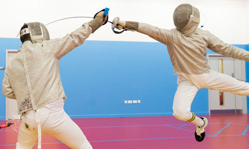 Two people fencing with sabres drawn