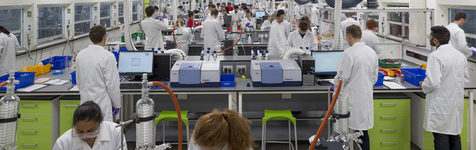 Students in lab coats working in a chemistry laboratory