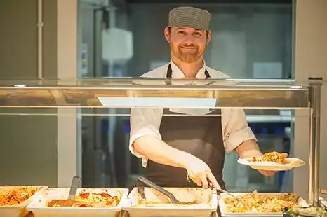 Chef at Cripps Hall preparing dinner for catered residents